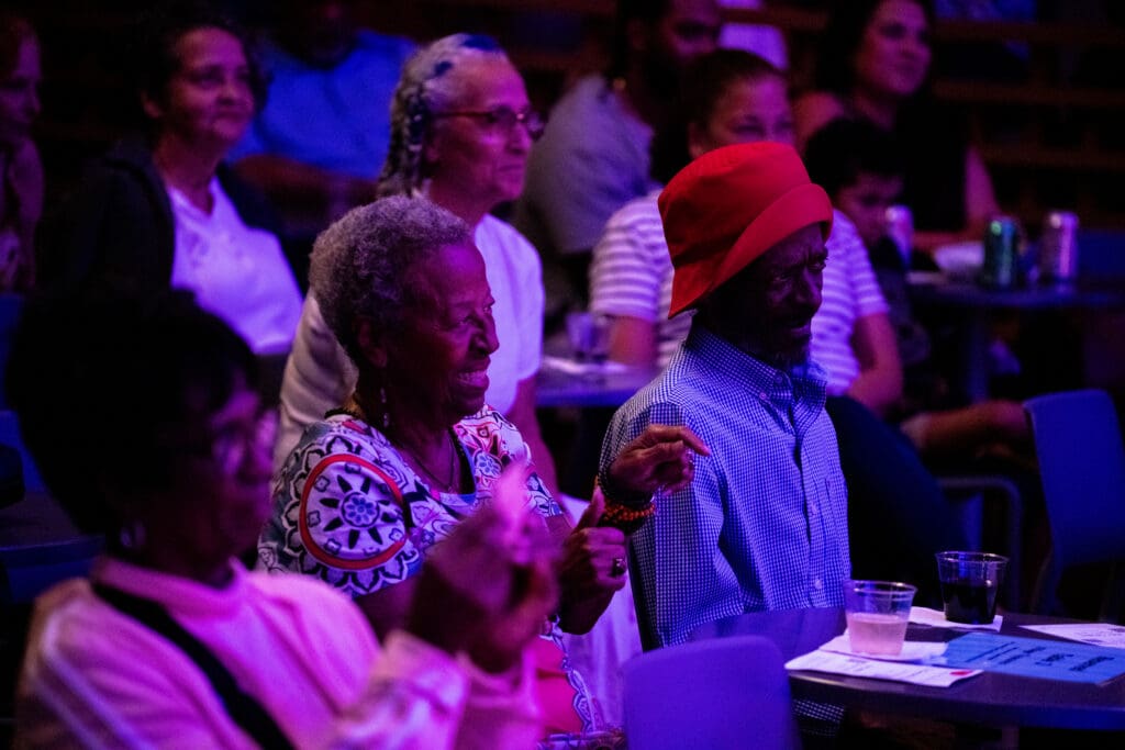 Audience members at a concert clapping.