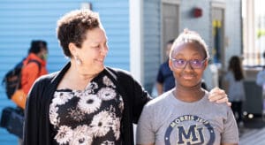 Adult staff member looks kindly at a student.